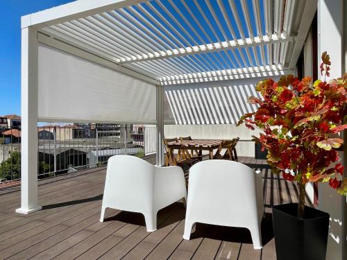 dos sillas blancas y una mesa en una terraza en Porto XL, en Oporto