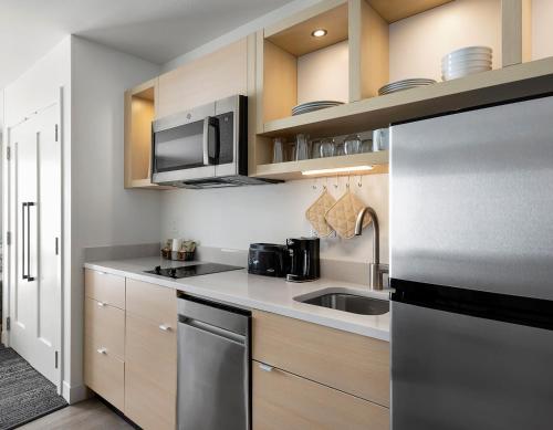 a kitchen with a sink and a microwave at TownePlace Suites by Marriott Iron Mountain in Iron Mountain