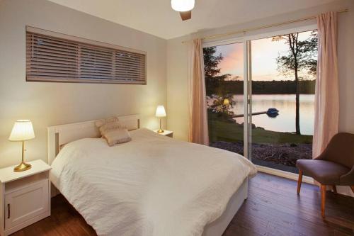 1 dormitorio con cama y ventana grande en Lakeside Lodge with Studio Apartment, en Monticello