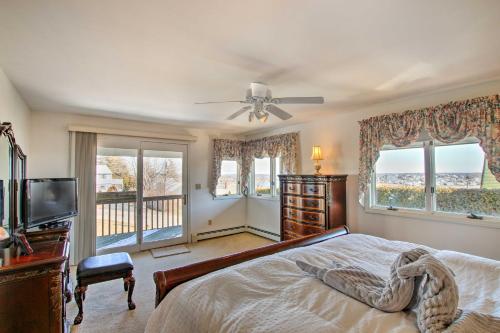 a bedroom with a bed and a tv and windows at Narragansett Home with Scenic Deck Less Than 2 Mi to Beach! in Narragansett