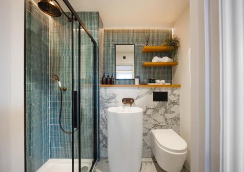 a bathroom with a shower with a toilet and a sink at Hive Townhouse in Aberaeron