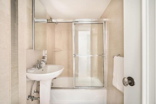 ein Bad mit einer Glasdusche und einem Waschbecken in der Unterkunft 73-919 New Studio UWS Doorman Gym in New York