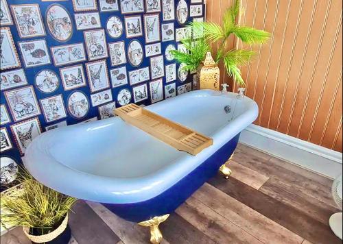 a blue bath tub in a room with a wall of pictures at Blue Cheetah Lemur Lodge in Bournemouth