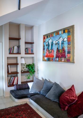 a couch in a living room with a painting on the wall at Ettys Villa in Giv'at Yo'av