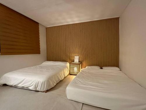 twee bedden in een slaapkamer met een lamp ertussen bij Soso guwol #Guwoldong stay #beam project #OTT #clean in Incheon