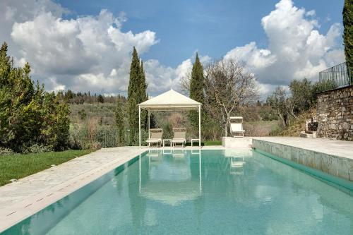 uma piscina com duas cadeiras e um gazebo em Il Poggetto em Rignano sullʼArno