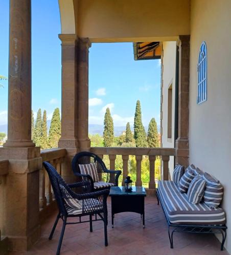 a patio with chairs and a table and a balcony at Park Palace Hotel in Florence