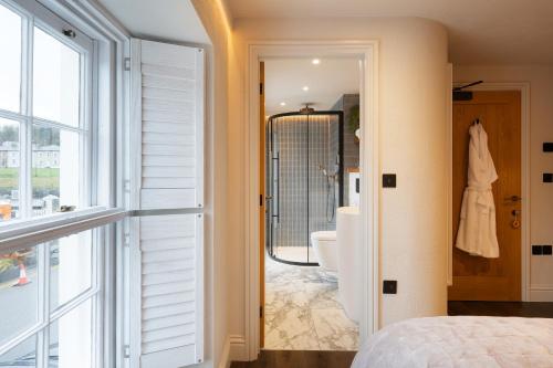 a bedroom with a door leading to a bathroom with a tub at Hive Townhouse in Aberaeron