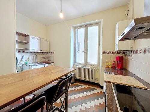 une cuisine avec une table en bois et quelques chaises dans l'établissement Appart de L'ile, 55M2 FIBRE, à Grenoble