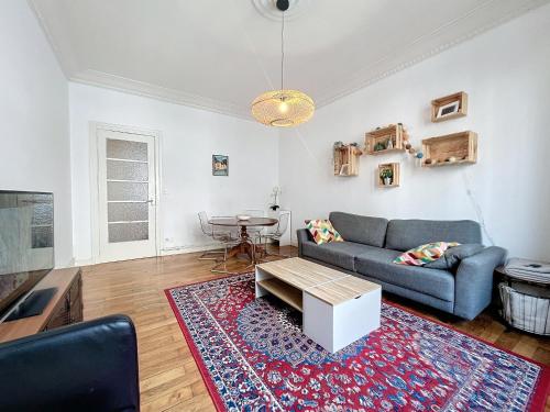 sala de estar con sofá y mesa en Appart de L'ile, 55M2 FIBRE, en Grenoble