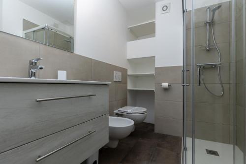 a bathroom with a toilet and a glass shower at Piazza del Lago Suites - Menaggio in Menaggio