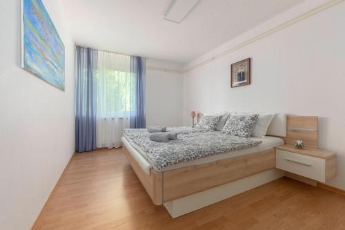 um quarto com uma cama num quarto branco em BH ROSE Apartment em Ljubljana