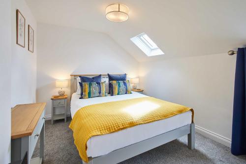 a bedroom with a bed with a yellow blanket at Host & Stay - Rose Cottage in Thropton