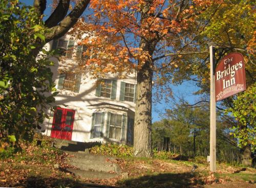 a white house with a sign in front of it at The Bridges Inn at Whitcomb House B&B in Swanzey