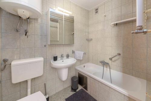 uma casa de banho com um lavatório, um WC e uma banheira em BH ROSE Apartment em Ljubljana