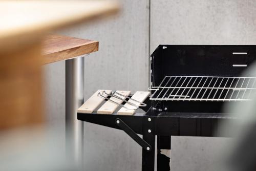 a grill with tongs sitting on top of it at Apartment Am Tobelbach in Oberlenningen