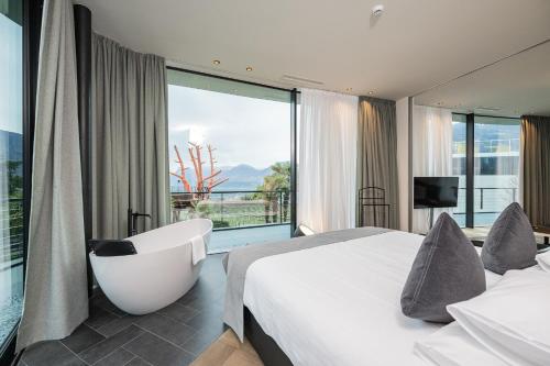 Habitación de hotel con bañera y dormitorio con vistas. en Hotel Gartner, en Tirolo