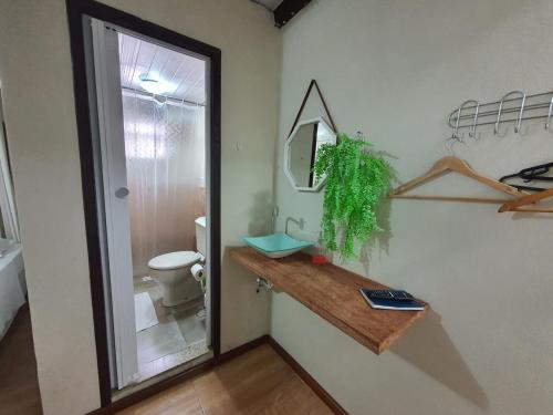 a bathroom with a toilet and a mirror on a wall at Pousada Tuiuiu in Angra dos Reis