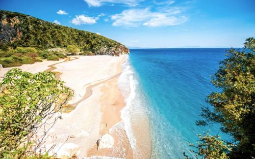 an aerial view of a sandy beach next to the ocean at Oasis Hostel in Himare