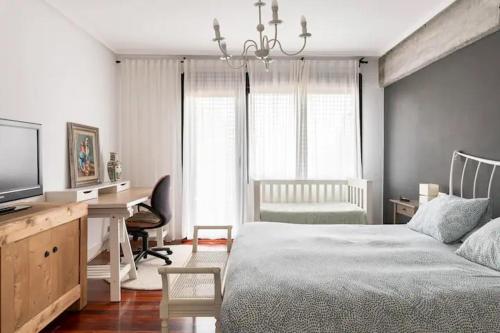 a bedroom with a bed and a desk and a television at Karaltzos LB00530 in Lezama