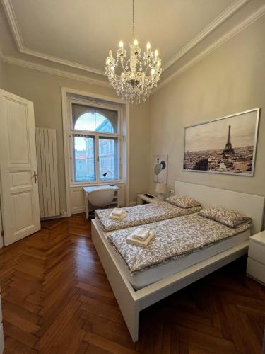 1 Schlafzimmer mit 2 Betten und einem Kronleuchter in der Unterkunft Four reasons apartment in Prag