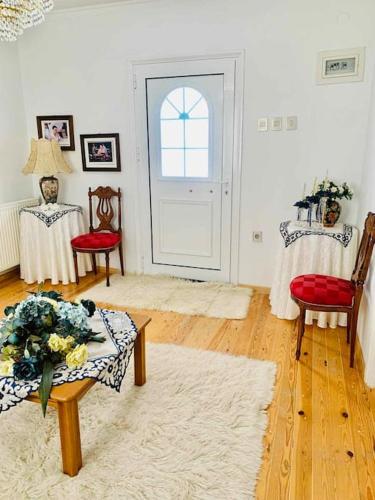 a living room with a table and chairs and a door at Το Αρχοντικό Της Βέτας Στον Όλυμπο! in Pýthion