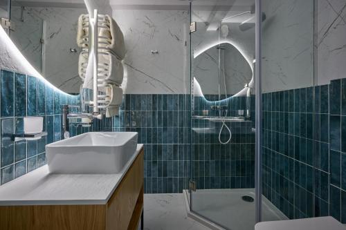 a bathroom with a sink and a shower and a mirror at Hotel Vedmezhyi Dvir in Bukovel