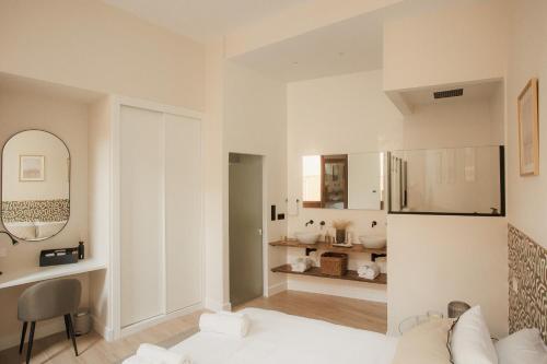 Sala de estar blanca con sofá y espejo en Apartamentos Cervantes en Badajoz
