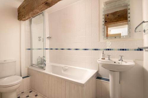 a bathroom with a toilet and a sink and a shower at Old Round House with hot tub in Padstow