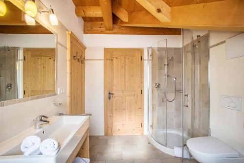 La salle de bains est pourvue d'une baignoire, d'une douche et d'un lavabo. dans l'établissement Stoffnerhof Apt Alpenrose, à Monguelfo-Tesido
