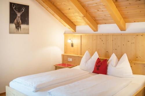 a bedroom with a white bed with red pillows at Stoffnerhof Apt Alpenrose in Tesido