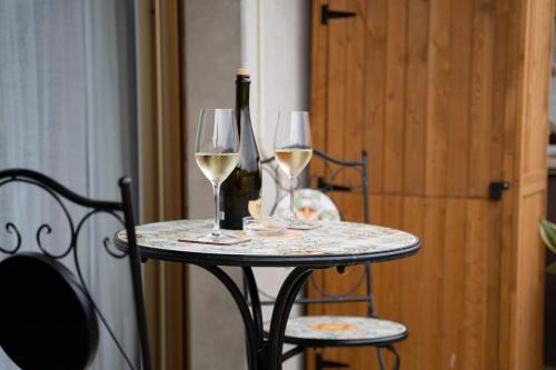 een tafel met twee glazen witte wijn erop bij Adagio Suite in Rapallo