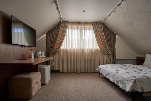 a bedroom with a bed and a large window at Hotel Vedmezhyi Dvir in Bukovel