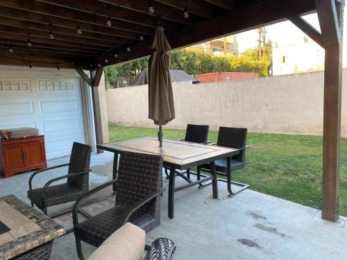 uma mesa com cadeiras e um guarda-sol num pátio em An Amazing comfortable home front house em Los Angeles
