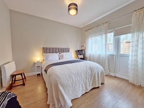 a bedroom with a bed and a large window at The Shed - Pulborough in Pulborough