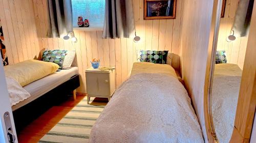 a small bedroom with two beds and a table at Berlevåg Apartment in Berlevåg