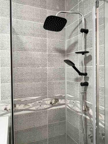 a shower with a glass door in a bathroom at Nessi Apartment in Pristina