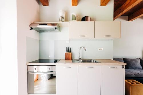 a kitchen with white cabinets and a sink at Apartment House Blazar in Tolmin