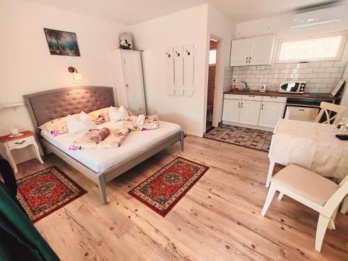 a small bedroom with a bed and a kitchen at Elisoria Apartments in Cserszegtomaj