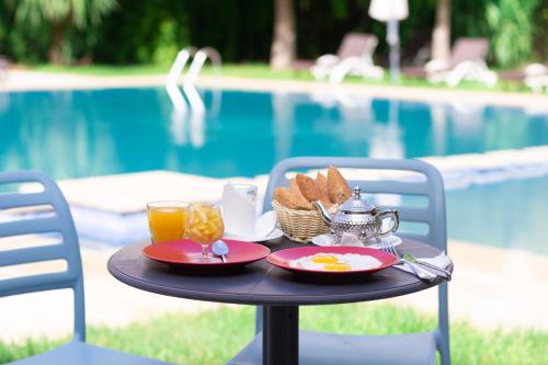 a table with a tray of food on it next to a pool at Ibis Oujda in Oujda