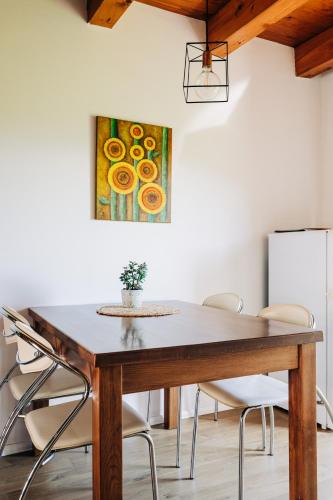 a dining room table with chairs and a painting on the wall at Apartment House Blazar in Tolmin