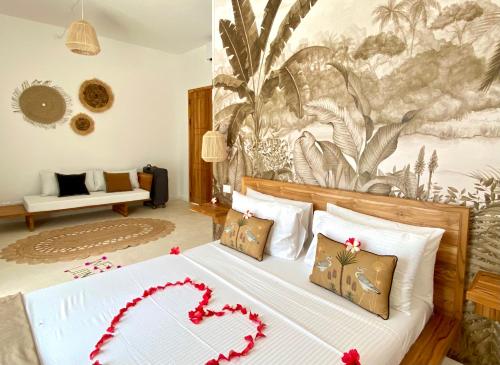 ein Schlafzimmer mit einem Bett mit einem Herz darauf in der Unterkunft Lions Grand SUITE Ocean Front Beach & Pool in Bunju