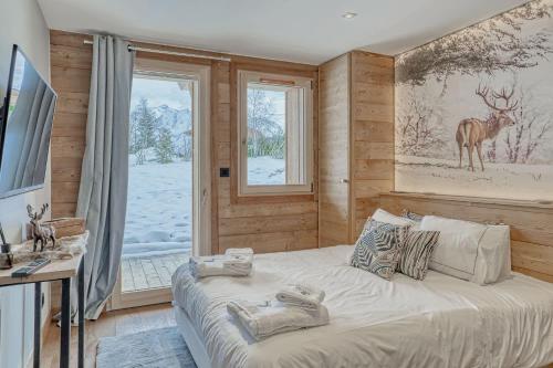 a bedroom with a bed with a picture of a deer on the wall at Chalet Indiana in Combloux