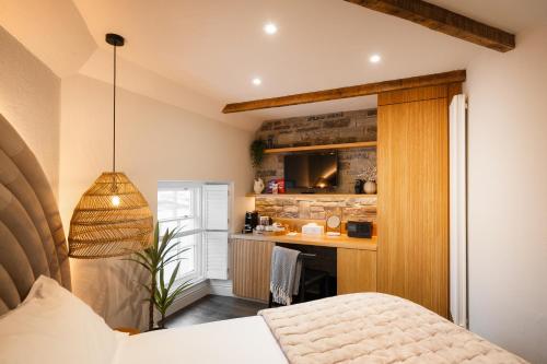 a bedroom with a bed and a kitchen at Hive Townhouse in Aberaeron