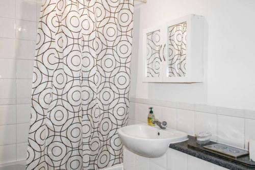 a bathroom with a sink and a shower curtain at Modern 2-Bed in Watford Centre in Watford