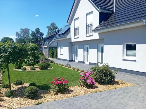 a house with some flowers in a yard at Ambiente-Annabelle in Göhren-Lebbin