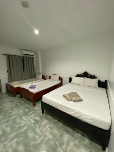 a bedroom with two beds and a couch in it at North Shores Inn in Currimao