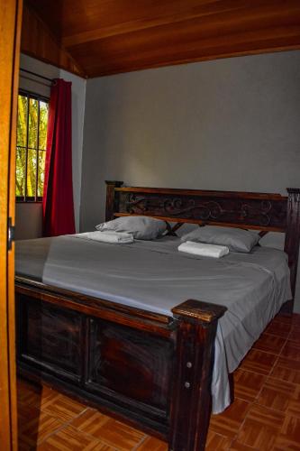 a bedroom with a bed with a wooden headboard at Finca Makambu in Platanillo