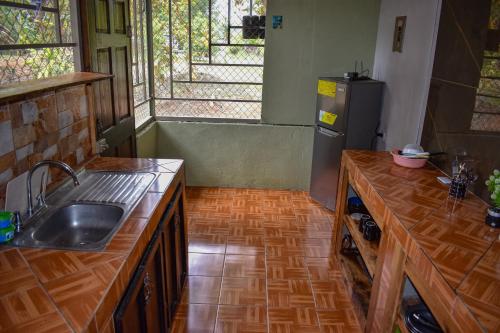 a kitchen with a sink and a refrigerator at Finca Makambu in Platanillo