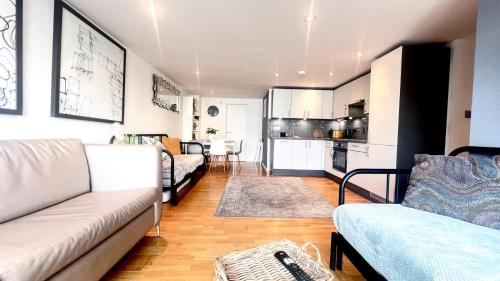 un soggiorno con divano e una cucina di Cosy Ground Floor Apartment a Londra